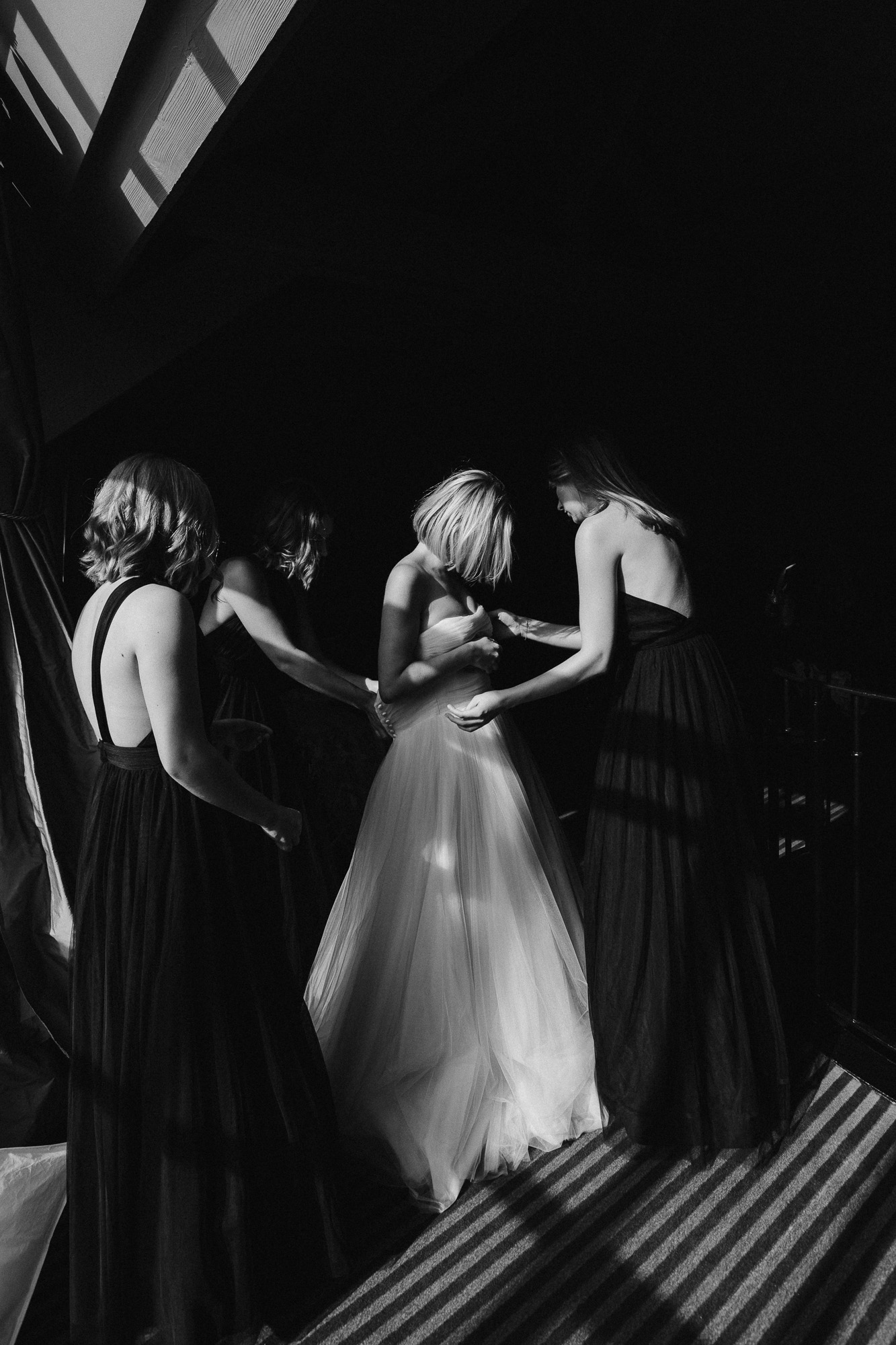 Paris wedding photographer: the bride is being helped into her lovely suzanne neville dress by her mum and bridesmaids