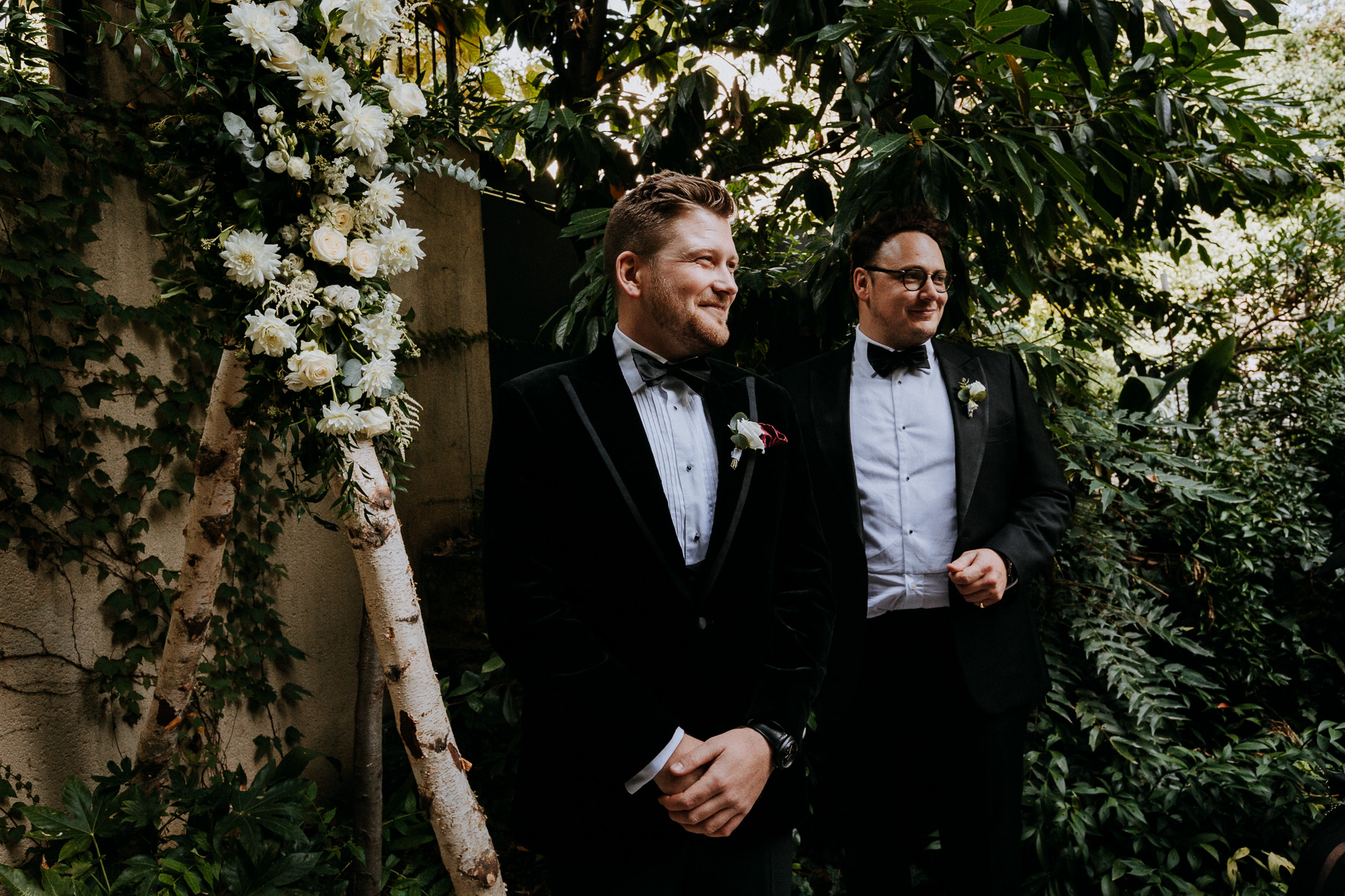 Paris wedding photographer: Portrait of the groom showing emotion as he watches his bride walk up the aisle - in the background his best man seem almost as overwhelmed as him.