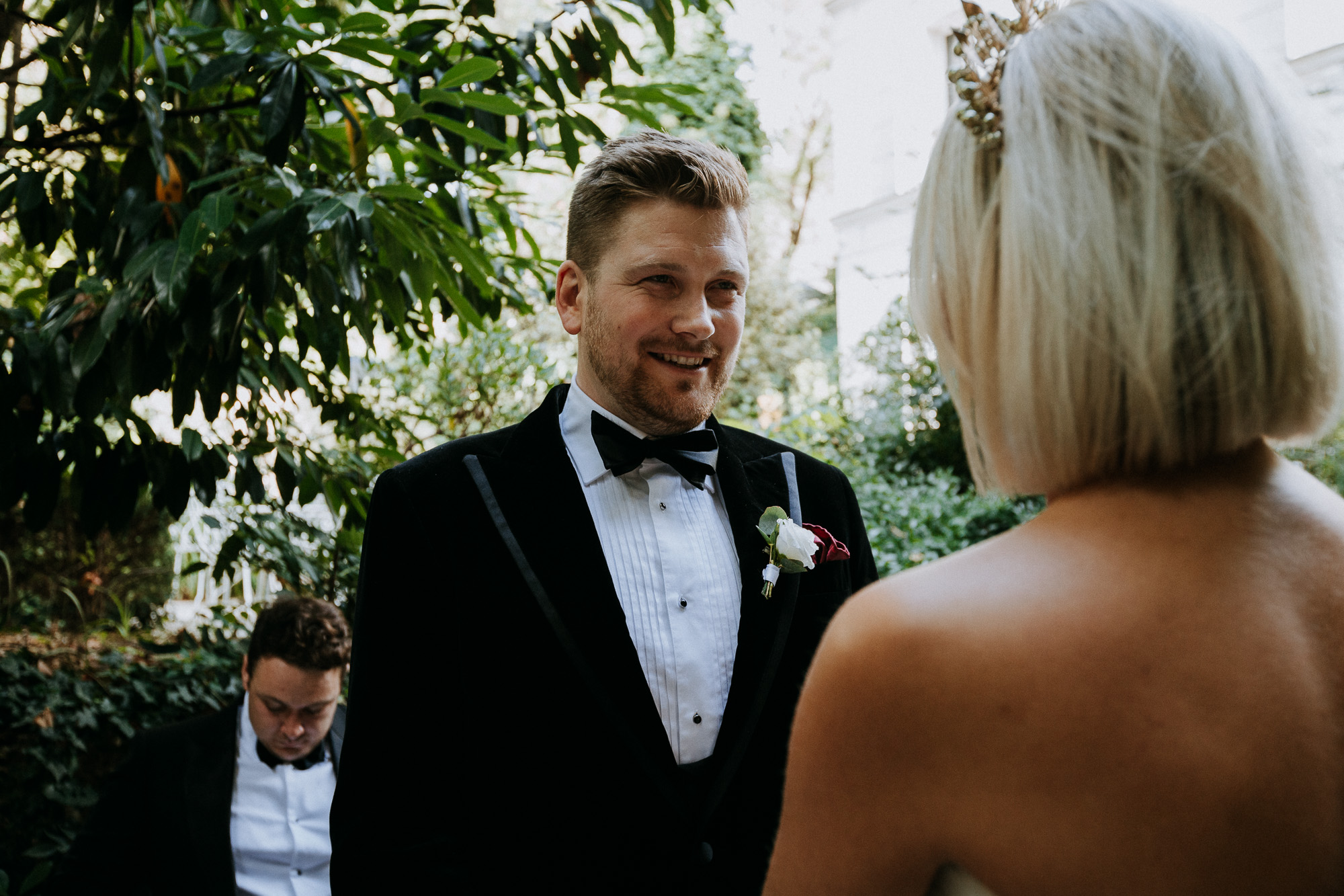 Paris wedding photographer: the groom lovingly looks at his wife during their wedding ceremony
