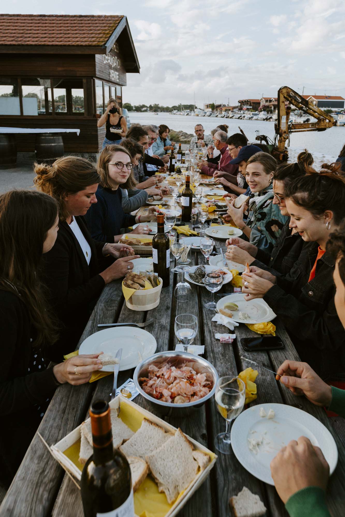 Arcachon wedding photographer: the wedding guests and newlyweds enjoy the last dinner of the celebratory weekend at one of the famous oyster huts, Kabane 171