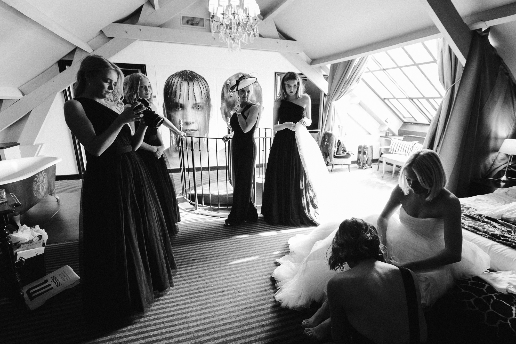 les touches finales sont apportées à la tenue de la mariée, ses demoiselles d'honneur et sa maman l'admirant dans la Suite Eiffel de l'Hôtel Particulier à Montmartre
