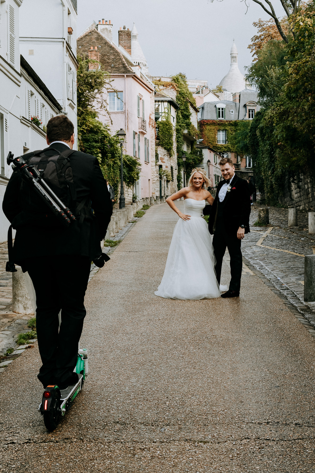 le témoin du marié prend le rôle d'assistant photographe et est ravit de trouver une trottinette pour accompagner la séance photo des mariés