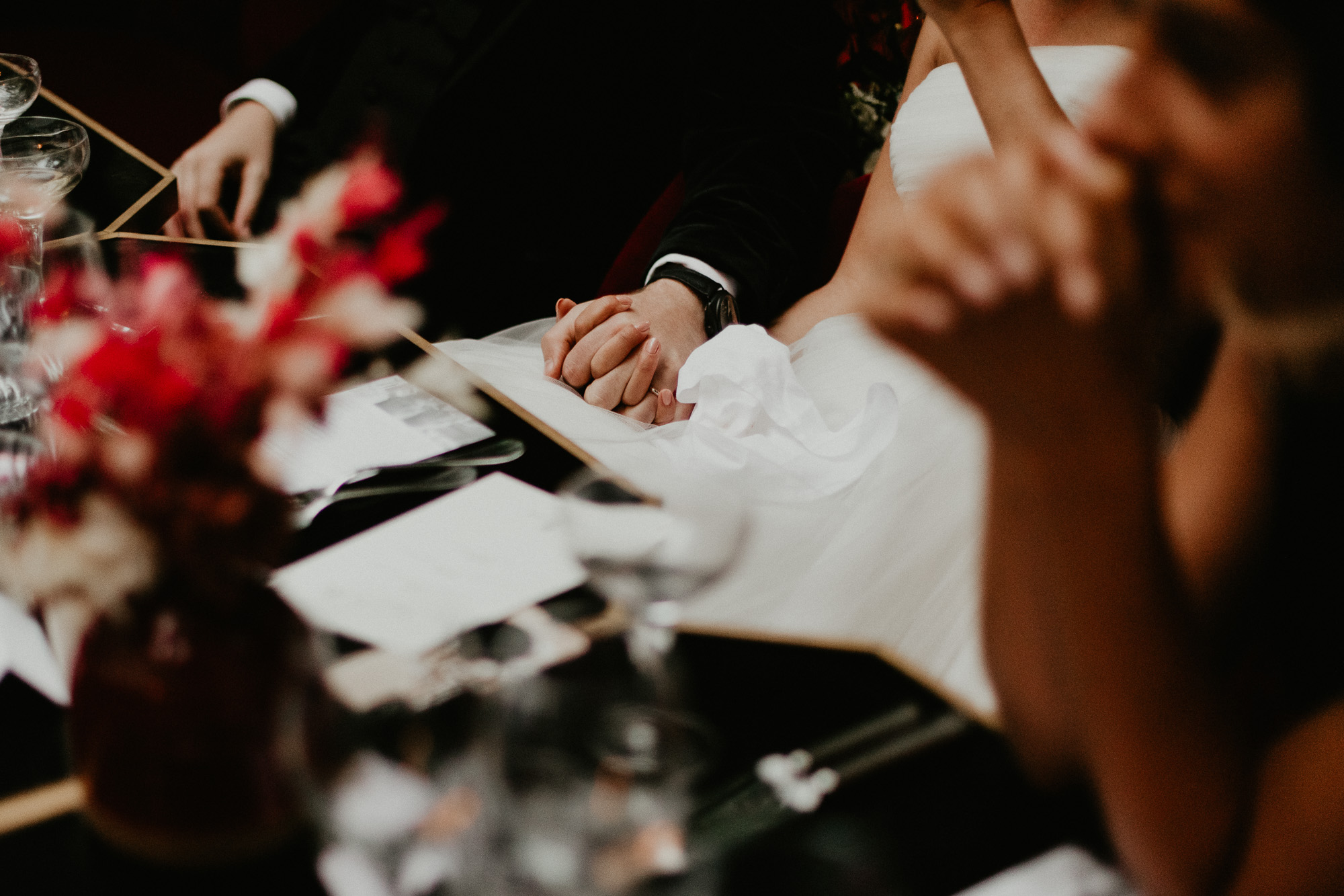 les mariés, attablés pour le diner, se tienne la main sous la table