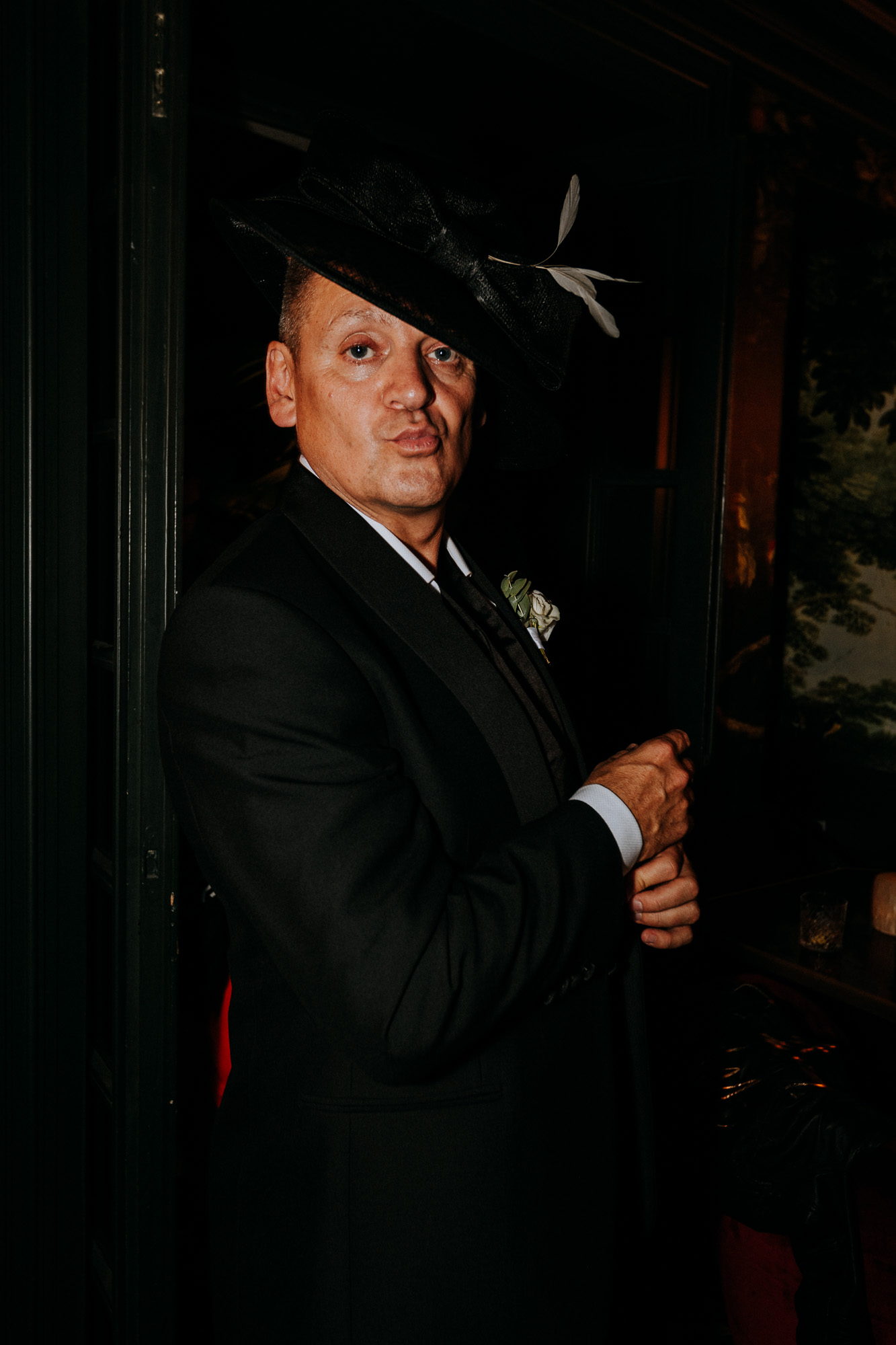 le père de la mariée pose avec un chapeau emprunté à une des invitées
